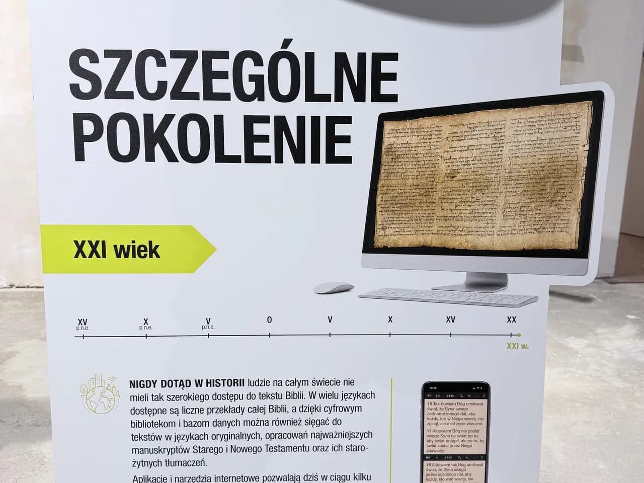 Plansza wystawy „Szczególne pokolenie” z działu „Współczesność”: na ekranie komputera fotografia starożytnego rękopisu, obok oś czasu do XXI wieku.